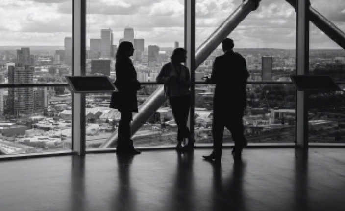 an image of three people looking out a window at a city skyline